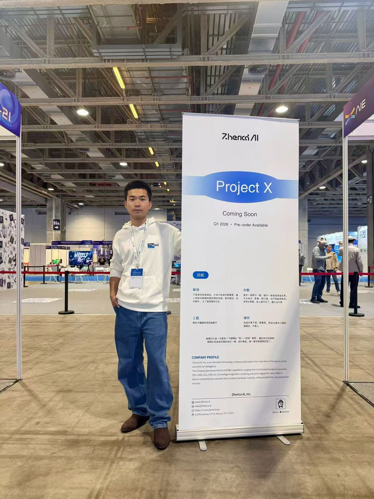 Standing beside a Project X booth display at an expo