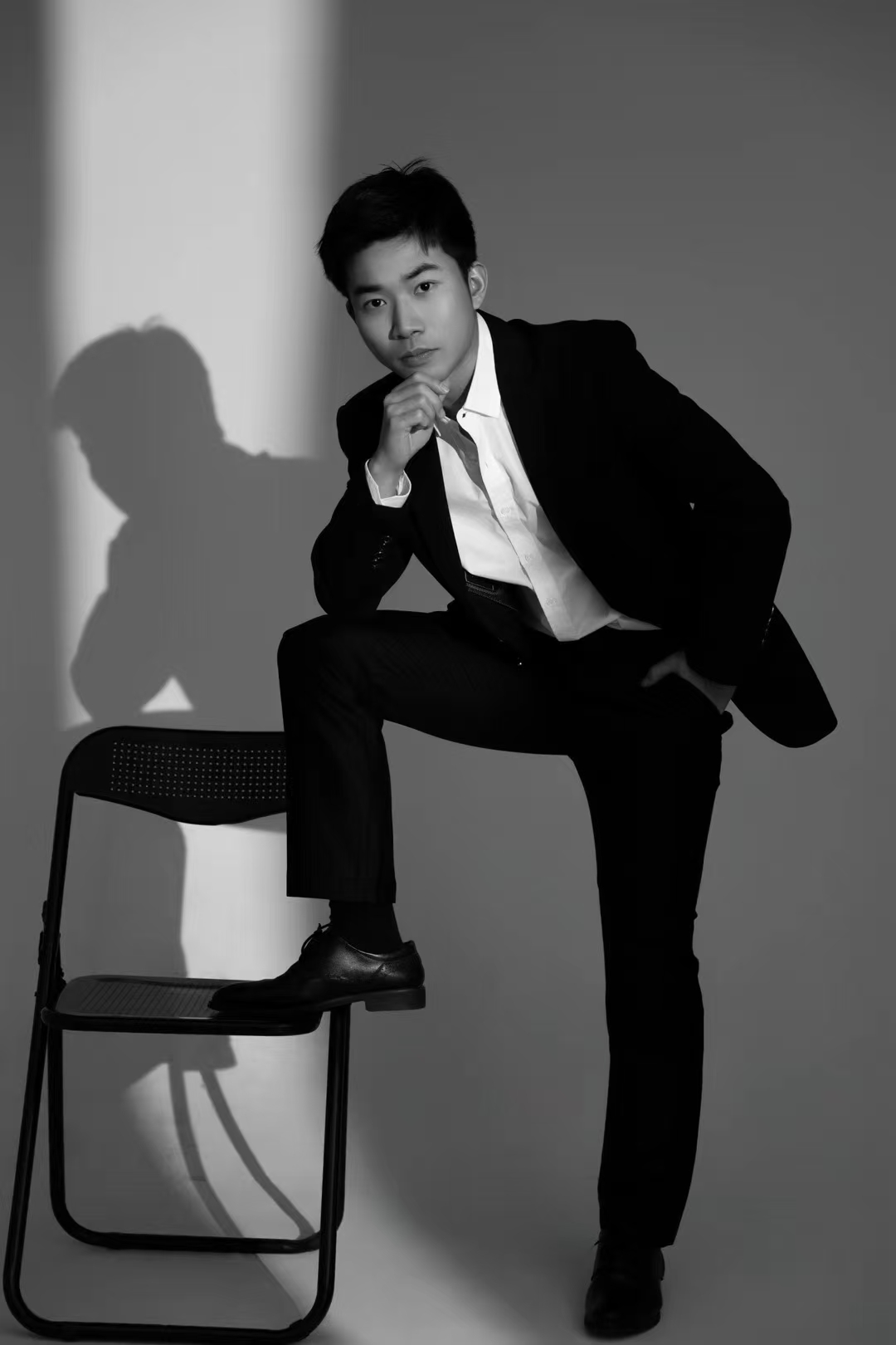 Black-and-white studio portrait in a suit